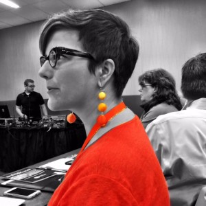 Amy Higgins adds edge with gradient orange drop earrings.